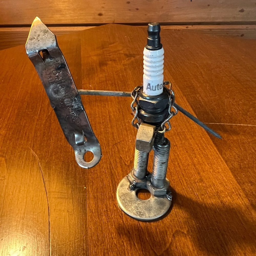 Spark plug snowboarder figure with gold medal.